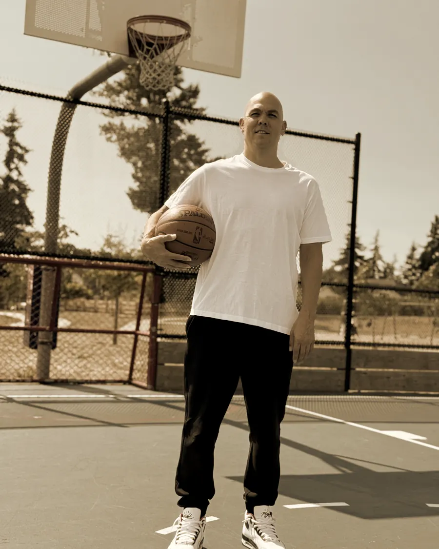 Jeremy Green standing on an outdoor court with a basketball under his arm